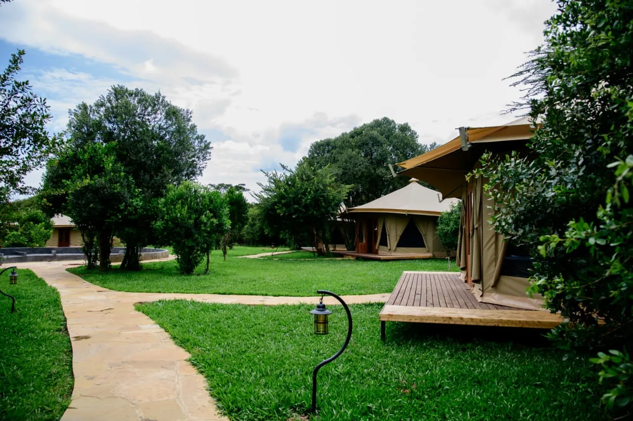 Tented suites with timber decks set along a flagstone path through the village garden